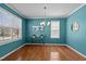 Bright dining room with hardwood floors, modern chandelier, and large windows offering abundant natural light at 9117 Cornwell Dr, Wake Forest, NC 27587