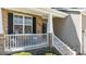 Inviting porch with stone pillars, comfortable seating, and decorative door at 9117 Cornwell Dr, Wake Forest, NC 27587