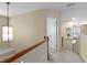 Upstairs hallway featuring neutral walls and a view into a brightly lit bedroom space at 9117 Cornwell Dr, Wake Forest, NC 27587