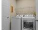 Clean laundry room with white front-load washer and dryer and a wire rack shelf at 9117 Cornwell Dr, Wake Forest, NC 27587