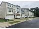 Street view of newly constructed townhomes featuring multiple units, garages, and landscaping at 10004 Secluded Garden Drive Rd # 180, Apex, NC 27523