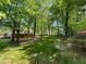Lush backyard showcasing mature trees, manicured lawn, and a relaxing deck area for outdoor enjoyment at 102 Caymus Ct, Cary, NC 27519