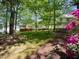 Spacious backyard featuring a lush lawn, mature trees, and a charming deck with stairs at 102 Caymus Ct, Cary, NC 27519