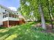 The backyard features a spacious deck, a screened-in porch, and lush green grass and mature trees at 102 Caymus Ct, Cary, NC 27519