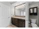 Bathroom featuring double sinks with granite countertops, dark wood cabinets, and a toilet at 102 Caymus Ct, Cary, NC 27519