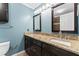 Bathroom featuring a double vanity with granite countertops, dark wood cabinets, and a tile backsplash at 102 Caymus Ct, Cary, NC 27519