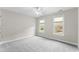 Bedroom features light-colored walls, gray carpet, ceiling fan, and natural light from the two windows at 102 Caymus Ct, Cary, NC 27519