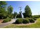 Community art in a landscaped area with decorative bushes, walking trails and mature trees at 102 Caymus Ct, Cary, NC 27519