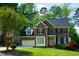 Charming brick home with lush green lawn, mature trees, and two-car garage at 102 Caymus Ct, Cary, NC 27519