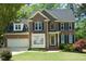 A beautifully landscaped brick-front home features classic shutters and manicured lawn at 102 Caymus Ct, Cary, NC 27519