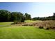 Scenic golf course view showcasing lush green grass and mature trees on a sunny day at 102 Caymus Ct, Cary, NC 27519