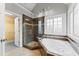 Main bathroom featuring a glass-enclosed shower, soaking tub, and a walk-in closet at 102 Caymus Ct, Cary, NC 27519