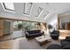 Bright living room with skylights, a modern sofa, and sliding doors to a deck at 10509 Leslie Dr, Raleigh, NC 27615