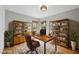 Charming home office with custom shelving, a rustic desk, and a comfortable leather chair at 10509 Leslie Dr, Raleigh, NC 27615