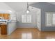 Dining room with hardwood floors, white walls, and natural light with views into the kitchen with wood cabinets at 113 Duchess Ln, Chapel Hill, NC 27517