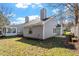 Rear exterior view of the home with gray siding, a patio, and a well-maintained lawn at 113 Duchess Ln, Chapel Hill, NC 27517