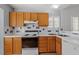 Kitchen featuring wood cabinets, white countertops, tile backsplash, and stainless steel appliances at 113 Duchess Ln, Chapel Hill, NC 27517