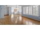 Bright living room with hardwood floors leads to a kitchen, features recessed lighting, and large windows with plantation shutters at 113 Duchess Ln, Chapel Hill, NC 27517