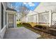 Concrete patio with an entry door and a white decorative fence at 113 Duchess Ln, Chapel Hill, NC 27517