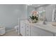 Bright bathroom with double sink vanity, white cabinets, and decorative orchids at 1203 Fairview Club Dr, Wake Forest, NC 27587