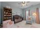 Charming Bedroom with hardwood crib, bookshelf, comfortable armchair, and bright windows at 1203 Fairview Club Dr, Wake Forest, NC 27587