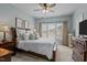 Bright bedroom with large windows, ceiling fan, and a comfortable king-size bed at 1203 Fairview Club Dr, Wake Forest, NC 27587