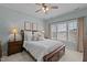 Bright bedroom with large windows, ceiling fan, and a comfortable king-size bed at 1203 Fairview Club Dr, Wake Forest, NC 27587
