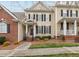 Charming two-story townhome featuring a brick accent wall and a welcoming front porch with a small garden at 1203 Fairview Club Dr, Wake Forest, NC 27587
