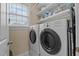 Well-lit laundry room featuring front loading washer and dryer and shelving at 1203 Fairview Club Dr, Wake Forest, NC 27587