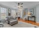 Inviting living room with stylish gray sofa, ottoman, and hardwood floors at 1203 Fairview Club Dr, Wake Forest, NC 27587