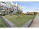 Expansive community lawn with young trees and landscaping, providing an inviting green space for outdoor activities at 1230 Coach Station Alley # 101, Raleigh, NC 27601