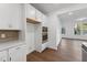 Bright kitchen featuring white cabinetry, stainless steel appliances, and hardwood floors, seamlessly flowing into the living space at 1230 Coach Station Alley # 101, Raleigh, NC 27601