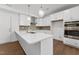 Modern kitchen showcasing white cabinets, quartz countertops, stainless steel appliances, and a stylish pendant light at 1230 Coach Station Alley # 101, Raleigh, NC 27601