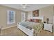 Neutral bedroom with two windows, ceiling fan, green bedding and natural light at 12504 Ribbongrass Ct, Raleigh, NC 27614