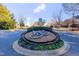 Well-maintained community entrance featuring manicured landscaping, seasonal flower beds, and decorative stone features at 12504 Ribbongrass Ct, Raleigh, NC 27614