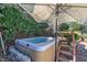 Inviting hot tub surrounded by lush greenery and under a shaded umbrella for ultimate relaxation at 12504 Ribbongrass Ct, Raleigh, NC 27614