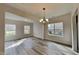 Bright dining room featuring hardwood floors, a stylish chandelier, and multiple windows that flood the space with natural light at 128 Chownings Dr, Sanford, NC 27330