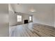 Spacious living room featuring hardwood floors, a cozy fireplace, and natural light, perfect for relaxing or entertaining guests at 128 Chownings Dr, Sanford, NC 27330