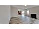 Bright living room featuring a cozy fireplace, hardwood floors, and a seamless transition to the modern kitchen at 128 Chownings Dr, Sanford, NC 27330