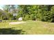 Large backyard featuring mature trees, a basketball court, and plenty of green space at 132 Lord Ashley Rd, Raleigh, NC 27610