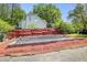 Backyard with gardening beds, a red fence, mulch ground covering, and green foliage, on a sunny day at 132 Lord Ashley Rd, Raleigh, NC 27610
