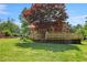 Backyard view featuring a wooden deck and mature trees providing shade at 132 Lord Ashley Rd, Raleigh, NC 27610