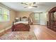 Bright bedroom with hardwood floors, a decorative rug, a window view, and a classic, wood-framed bed at 132 Lord Ashley Rd, Raleigh, NC 27610