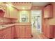 Traditional kitchen with ample cabinet storage, tile counters, and view to the living room at 132 Lord Ashley Rd, Raleigh, NC 27610