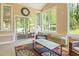 Inviting sunroom with natural light, wicker seating, a stylish area rug, and backyard views at 132 Lord Ashley Rd, Raleigh, NC 27610