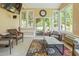 Bright sunroom featuring wicker furniture, area rug, tv, and scenic views of the surrounding landscape at 132 Lord Ashley Rd, Raleigh, NC 27610