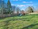Large backyard featuring a playset with swings and a slide and fully fenced perimeter at 132 Mantle Dr, Clayton, NC 27527