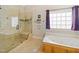 Inviting bathroom with a soaking tub, glass shower, and decorative window at 132 Mantle Dr, Clayton, NC 27527