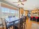Dining area with wooden table and chairs, large windows with bamboo blinds, hardwood floors, and access to kitchen at 132 Mantle Dr, Clayton, NC 27527
