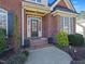 Inviting front door entrance to home featuring red brick steps and manicured landscaping at 132 Mantle Dr, Clayton, NC 27527